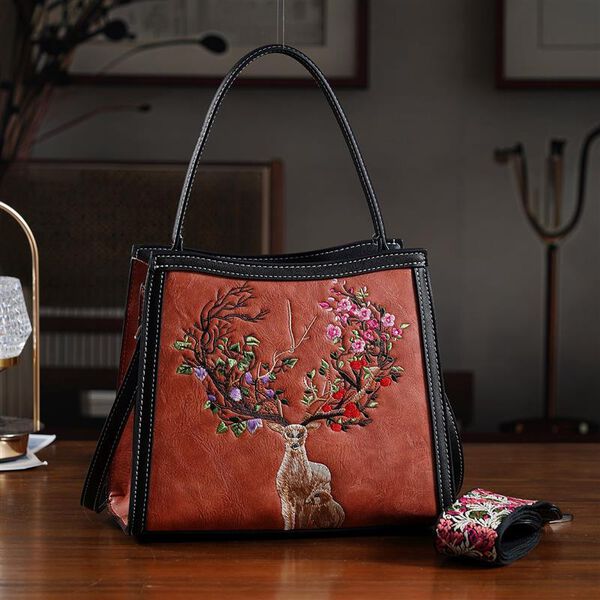 "PU Embroidered crossbody bag Color: Orange Size:  25*11*21cm   Wall: PU Lining: Polyester Exterior:zipped-1,pocket-1 Interior: zipped-2,slid-1 Long Shoulder strap:130cm " image number 1